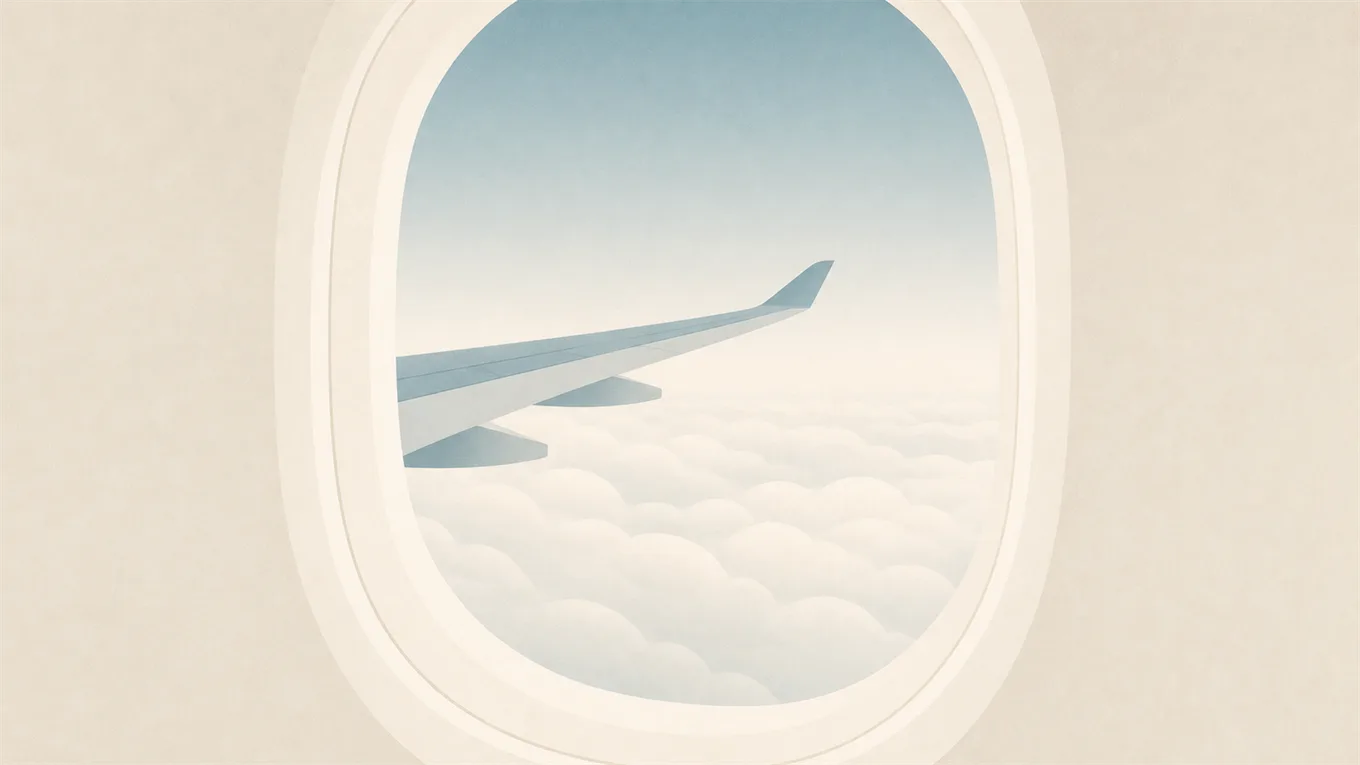 Un hublot d’avion, l’aile et des nuages doux